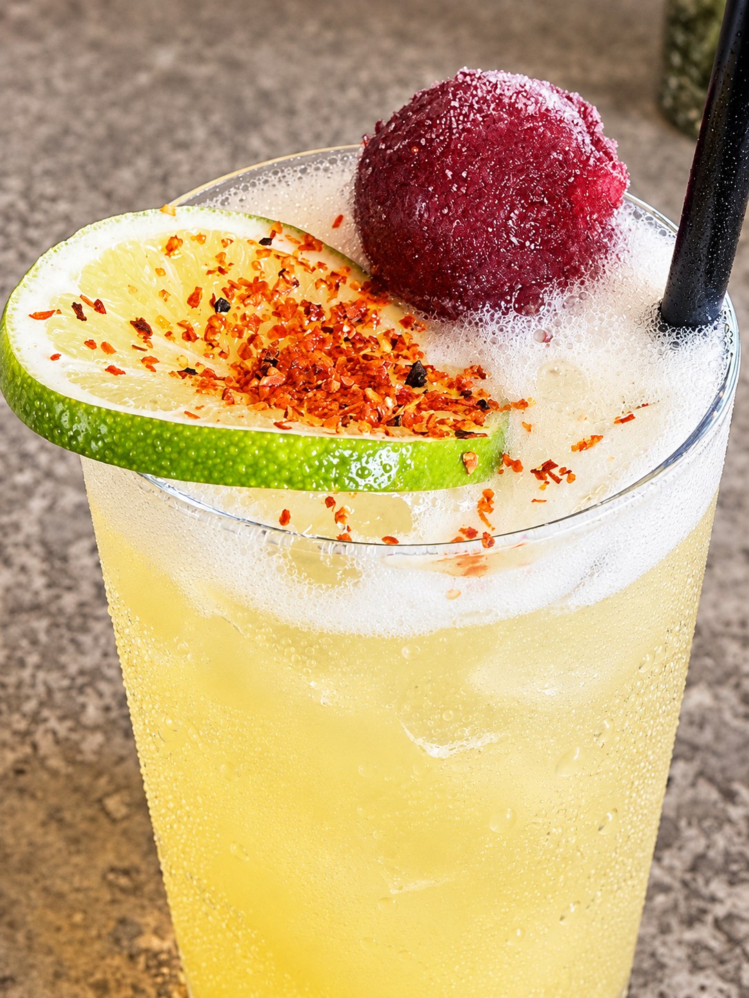 Frozen cocktail with lime and fruit garnish
